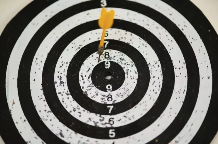 dart board with dart near the bullseye