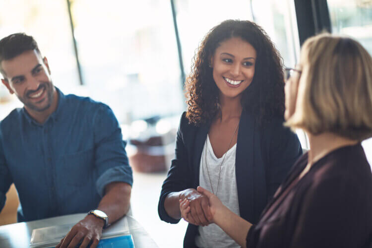 A photo of three people standing, two of which are shaking hands. They appear to be lawyers at an event celebrating International Be Kind to Lawyers Day